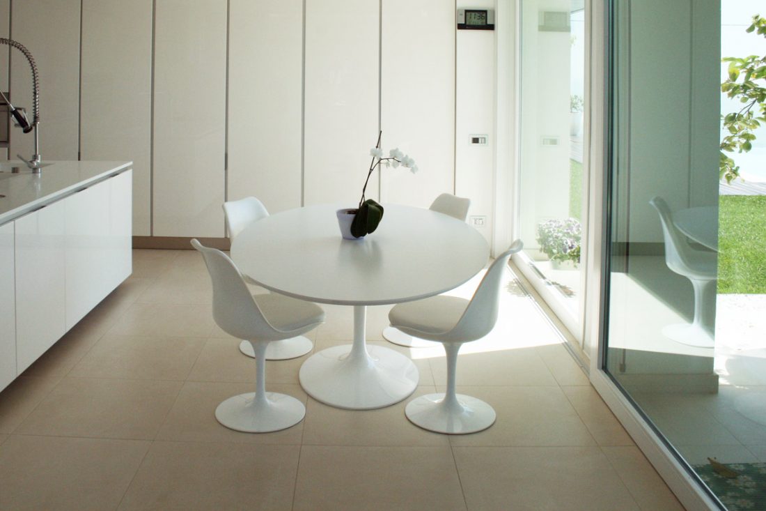 Immagine di una cucina moderna, con un tavolo saarinen modello tulip affacciato ad una grande vetrata