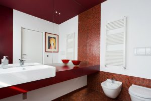 Un bagno moderno a tinte rosse decorato con un botero